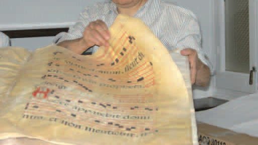 Dolors Domingo fullejant un cantoral probablement d’època barroca.